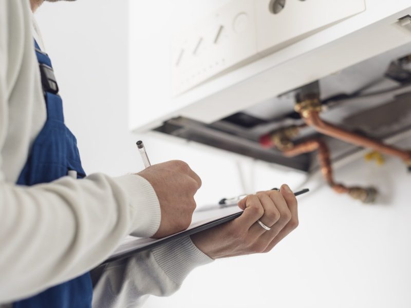 Professional plumber doing a boiler check