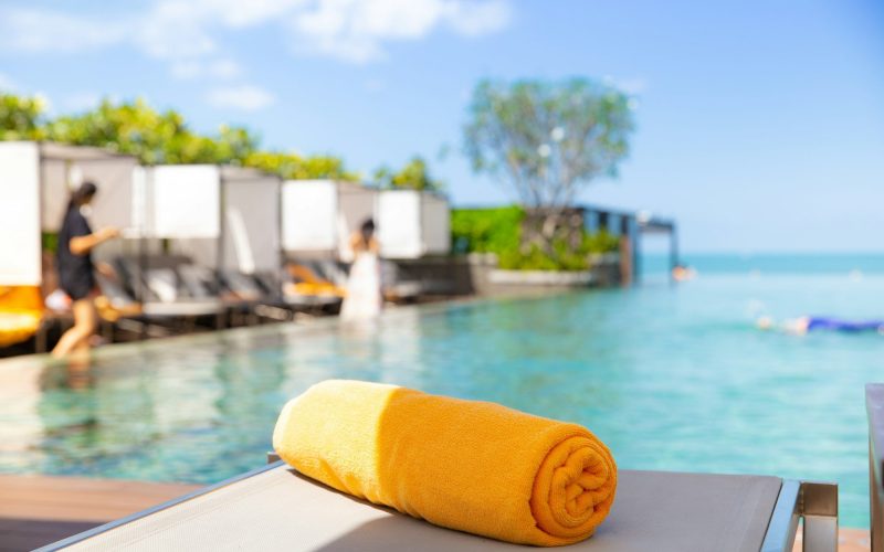 Yellow towel on the bed cushion by the infinity swimming pool.